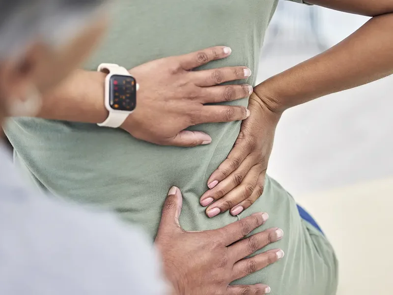 Physical therapist assessing a patient's low back movement and mobility