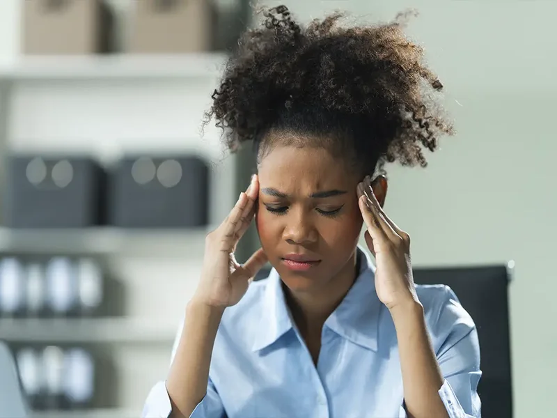 Physical therapist assessing a patient's neck and head movement for headache treatment