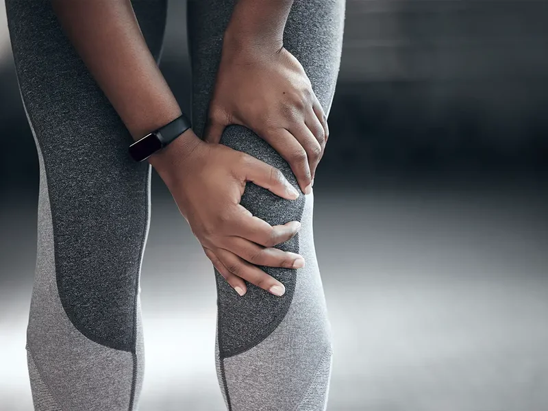 Physical therapist assessing a patient's hip and knee movement and mobility