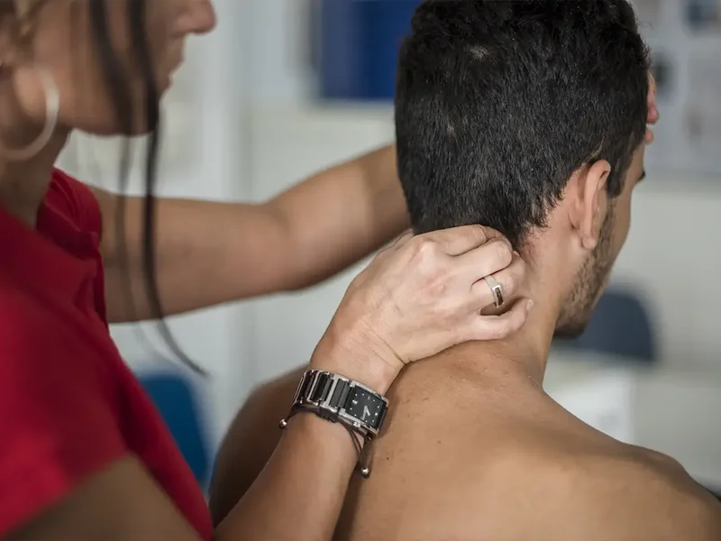 Physical therapist assessing a patient's neck movement and mobility