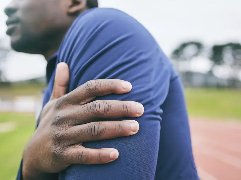Physical therapist assessing a patient's shoulder and rotator cuff strength
