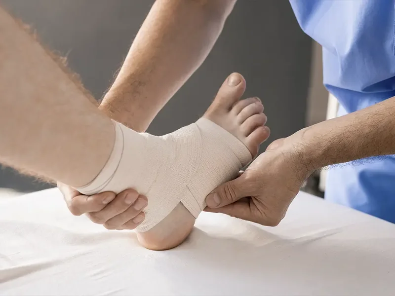 Physical therapist assessing a patient's ankle and joint mobility after a sprain