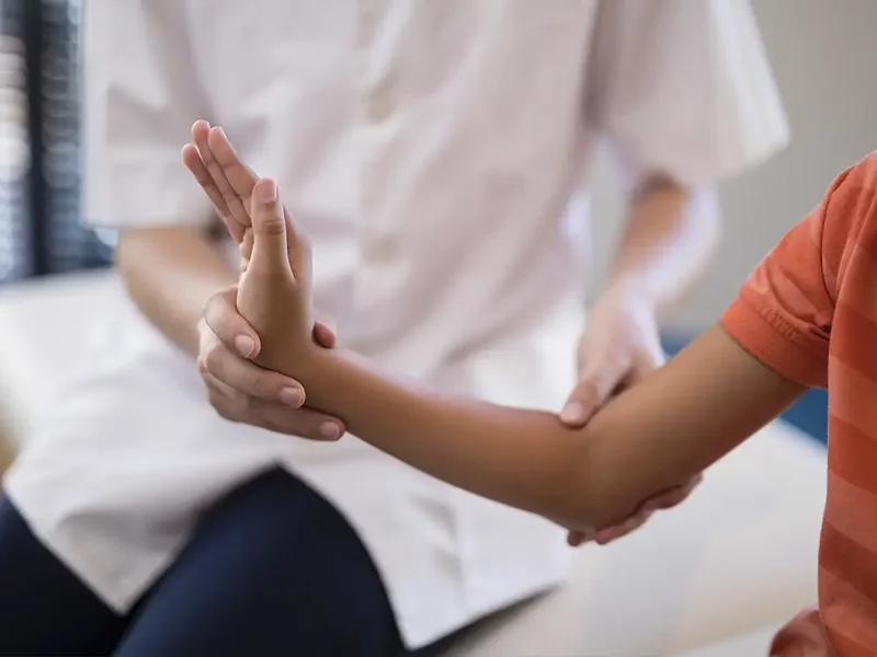 Physical therapist assessing a patient's tendon movement and mobility