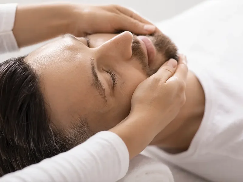 Physical therapist assessing a patient's jaw movement and mobility