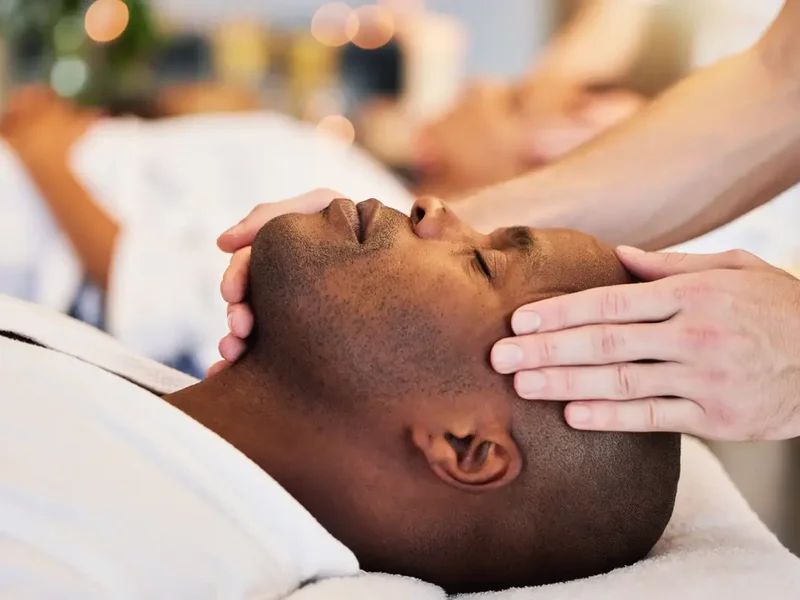Doctor of Physical Therapy performing craniosacral therapy at a patient's head and neck