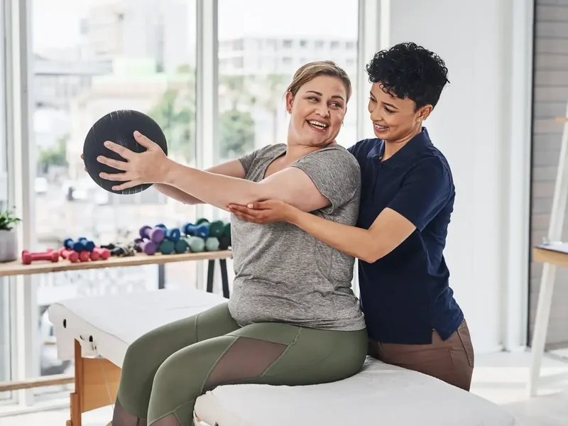 Physical therapist guiding a patient through a hands-on treatment session