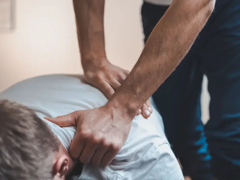 Physical therapist performing spinal manipulation on a patient