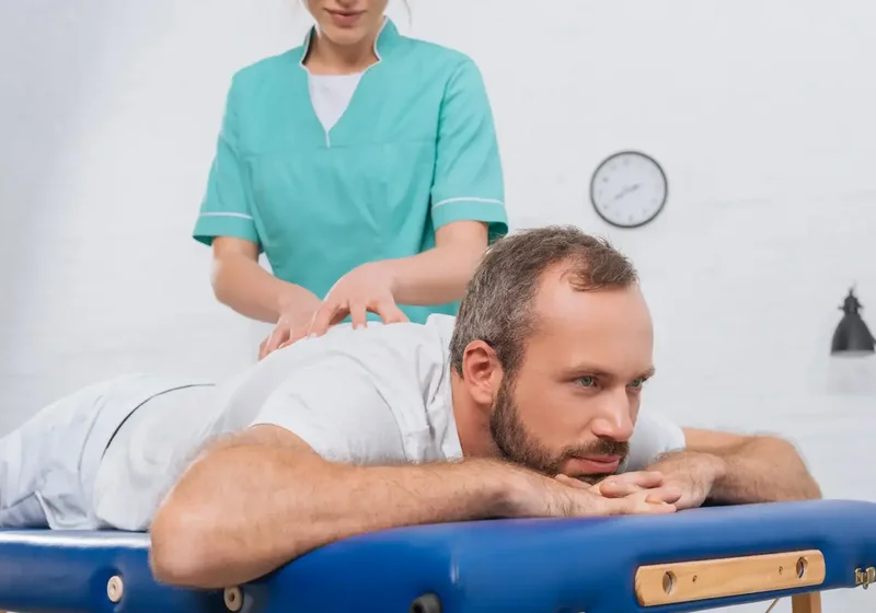 Physical therapist guiding a patient through a McKenzie Method mechanical diagnosis session